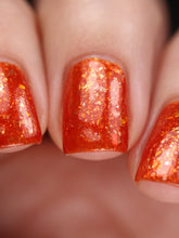 nail polish by crystal knockout, carnelian meld, red orange jelly with gold flakes and shimmer