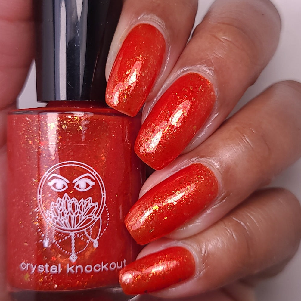 nail polish by crystal knockout, carnelian meld, red orange jelly with gold flakes and shimmer