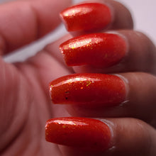 nail polish by crystal knockout, carnelian meld, red orange jelly with gold flakes and shimmer